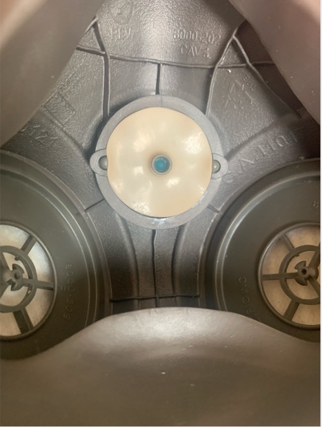 inside of moldex 8000 series with rubber circles removed from side filters, one rubber circle placed on post of central exhalation vent